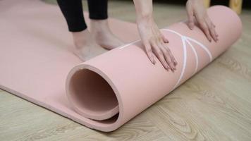 Close-up of a young woman's hand holding a fitness mat, home training, and the concept of a healthy lifestyle. photo