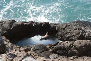 Rock at coastline sea water eroded photo