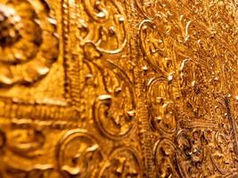 Beautiful Burmese art pattern motifs decorative design on the golden walls of the rooms in the temple photo