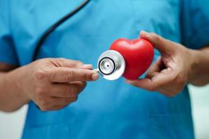 Asian woman doctor holding red heart for health in hospital. photo