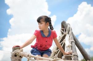 A little girl having fun swinging on a swing on a clear day photo