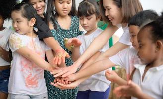 Children have fun playing with colors. They are holding hands photo