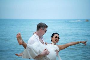 Interracial couple with the joy of traveling to the beautiful blue sea like the paradise photo