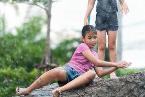 los niños se divierten jugando toboganes de lodo en los campos comunitarios. foto