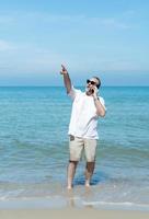 Foreign tourists stroll along Asia's beautiful blue sea beaches. Talking on the phone to a friend to describe the beauty of the beach photo