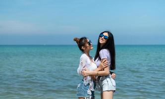 LGBT couples traveling around Asia, Swim happily on the sandy beach with the beautiful blue sea photo