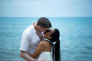 Interracial couple with the joy of traveling to the beautiful blue sea like the paradise photo