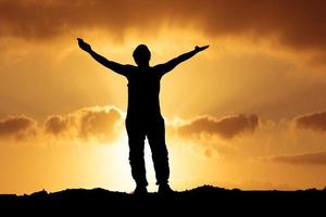 Silhouettes of men raising their hands in happiness and freedom on the mountain. photo