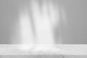 Marble Table with White Stucco Wall Texture Background with Light Beam and Shadow, Suitable for Product Presentation Backdrop, Display, and Mock up. photo