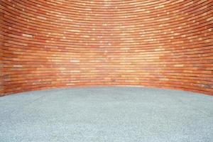 Red Brick Wall Background in Curved Style with Sand Pavement. photo