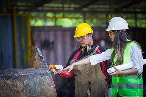 Asian female engineer checks workers' welds photo