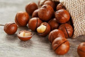 nuez de macadamia en una mesa de madera en una bolsa, primer plano, vista superior foto