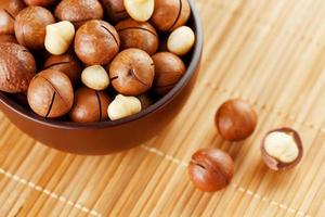 Macadamia nut on bamboo texture, concept of superfoods and healthy food