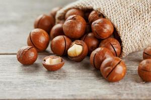 Macadamia nut on a wooden table in a bag, closeup, top view photo