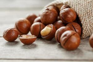 nuez de macadamia en una mesa de madera en una bolsa, primer plano, vista superior foto