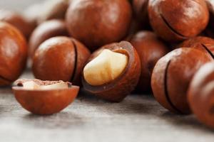 Macadamia nut on a wooden table in a bag, closeup, top view photo