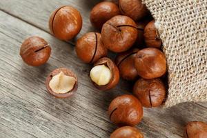 Macadamia nut on a wooden table in a bag, closeup, top view photo