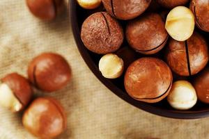 Macadamia nut on wooden background with vintage cloth, concept of superfoods and healthy food photo