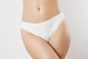 Template Blank Close up White Woman Panties isolated on gray background. Cropped image. Flat Belly and nutrition concept. Female health. Pain periods and cycle problems. Front view and copy space photo