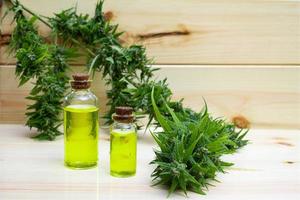 Oil cannabidiol CBD with bud marijuana on wood background photo