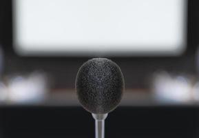 Close up microphone center of picture with screen projector background in meeting photo