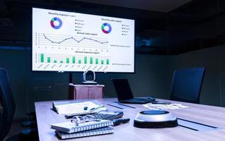 Mock up chart slide show presentation on display television and laptop in meeting room photo