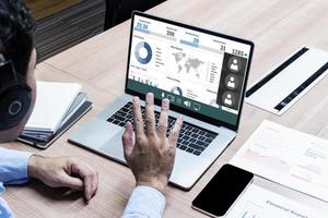 Business man with headphone looking to presentation on display laptop and raise hand greeting online meeting photo