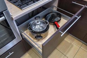 utensilios de cocina y utensilios domésticos en los estantes de la cocina foto