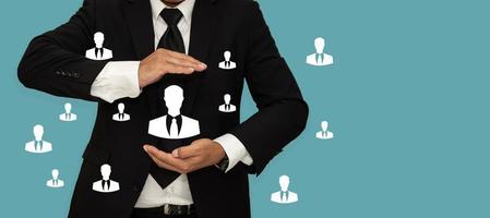 HRM or Human Resource Management, Business man holding human icons in hand with copy space. photo