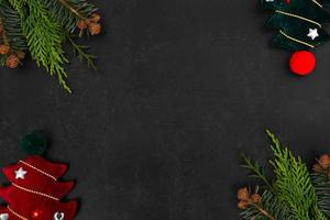 navidad o año nuevo fondo oscuro con ramas de abeto, tablero negro de navidad enmarcado con decoraciones de temporada, espacio para texto, vista desde arriba. foto