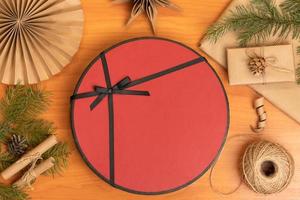 Christmas flat lay with a red gift box and handmade decor from craft paper photo