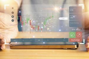 Businessman working with smartphone and virtual graphs, closeup. Financial trading concept photo