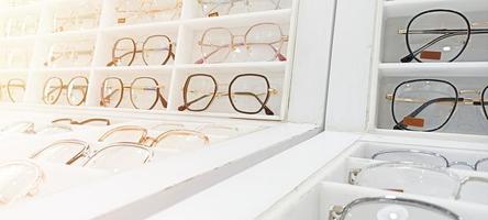 Several pictures of eyeglasses are placed on the shelf. photo