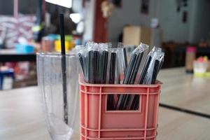 selective focus to black plastic straw isolated on blurred food stall background. soft focus photo