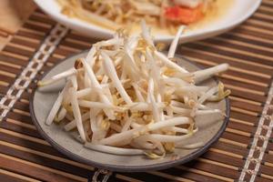 Bean sprouts in a plate on a wooden background photo
