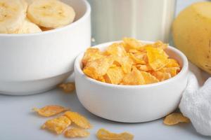 desayuno de copos de maíz, plátano, leche fresca, comida saludable foto