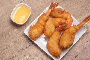 Battered shrimp with plum sauce in white plate photo