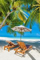 Beautiful panoramic nature. Tropical beach sunny as summer island landscape with chairs umbrella palm leaves calm sea shore, coast. Luxury travel panoramic destination banner for vacation or holiday photo