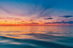 hermosa puesta de sol en la superficie del agua del océano. tranquilo verano meditación relajante paisaje marino. exótico amanecer playa rayos de sol, mar y horizonte. increíble vista de la naturaleza, olas cielo colorido. majestuosa playa costa orilla foto