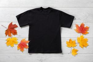 Front views of little boy in black t-shirt on white wooden background. Mockup for design photo