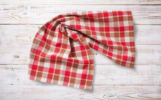 Towel or tablecloth, napkin, rough fabric texture with creased folds on wooden desk top view. photo