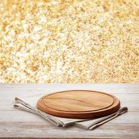 Pizza board, with napkin on wooden table closeup. Top view mockup. Festive sparkling gold background photo