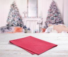 Wooden table with red napkin and Christmas background photo