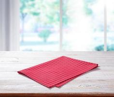 Wooden table with red napkin and window photo
