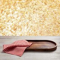 Pizza board, with napkin on wooden table closeup. Top view mockup. Festive sparkling gold background photo