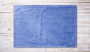 Smooth blue tablecloth, napkin, rough fabric texture on wooden desk top view. photo