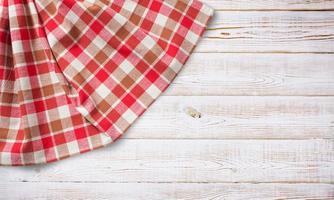 Towel or tablecloth, napkin, rough fabric texture with creased folds on wooden desk top view. photo