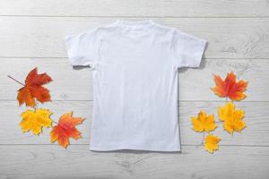 Back views of little boy in white t-shirt on white wooden background. Mockup for design photo