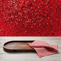 Pizza board, with napkin on wooden table. Top view mockup. Festive sparkling red background photo
