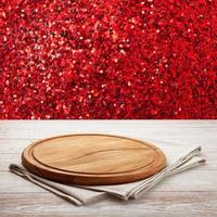 Pizza board, with napkin on wooden table. Top view mockup. Festive sparkling red background photo